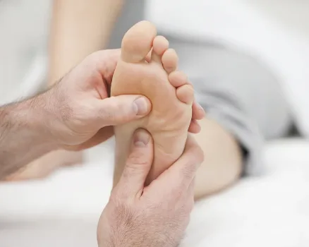 Sesión de reflexología podal en los pies vista desde otro ángulo con masaje en puntos energéticos