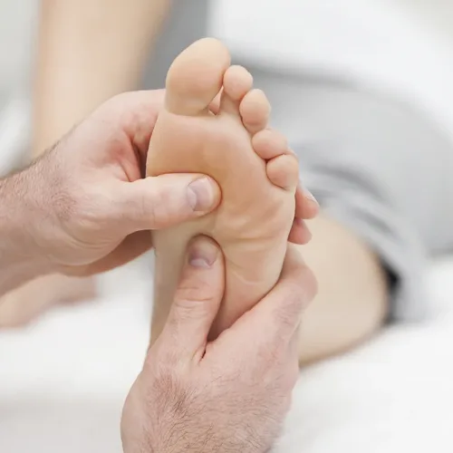 Sesión de reflexología podal en los pies vista desde otro ángulo con masaje en puntos energéticos