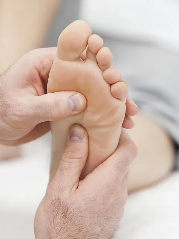 Sesión de reflexología podal en los pies vista desde otro ángulo con masaje en puntos energéticos